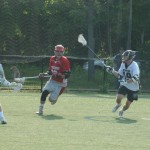 Tyngsboro’s Russell Gillis (red) attacks the cage